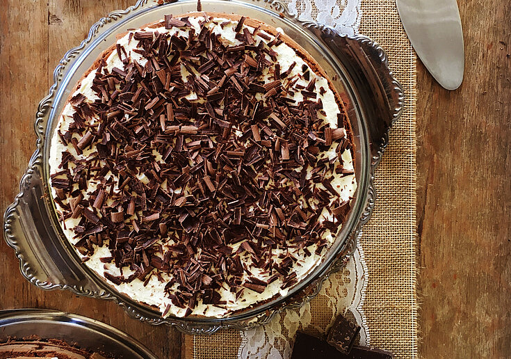 Muttertagsbuffet Schwarzwälderkirschtorte Auf dem rustikal gedeckten Tisch ist in der Mitte eine Schwarzwälderkirschtorte. Neben der Torte liegen Schokoladetafeln als Dekoration für das Bild.