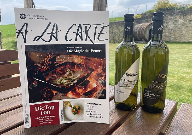 A la Carte Magazin mit jeweils einer Flasche BIO Weinviertel DAC und BIO Grüner Veltliner Reserve vom Weingut Neustifter.