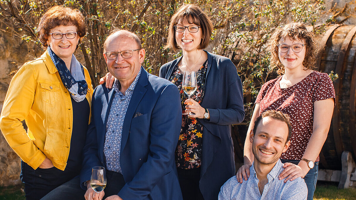 Brigitte, Karl, Monika, Laura und Roman Neustifter posieren für ein Foto im Gastgarten vom Wein.Gut Neustifter.