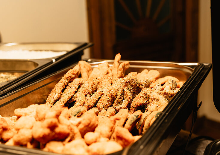 In dem Chevingtisch sind verschiedene Schnitzelsorten (Schweinsschnitzel mit normaler Panier und Hühnerschnitzel mit Kürbiskernpanier) eingewärmt.