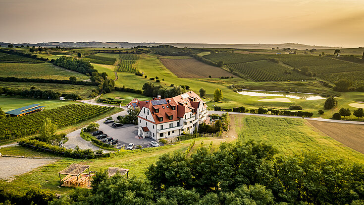 Eine Drohnenaufnahme zeigt das Wein.Hotel Neustifter von oben im Herbst.