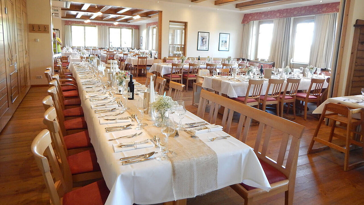 Alle Räume vom Wein.Restaurant sind offen, so dass ein einziger großer Raum entsteht. Die Tische sind zusammengestellt und mit weißen Tischtüchern eingedeckt.