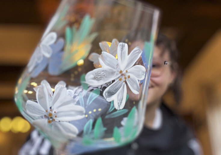 A painted wine glass with a floral pattern