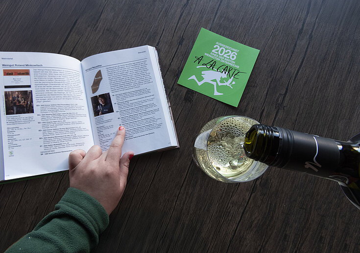 A la Carte Weinguide 2026 mit einem Glas Wein und einer Flasche Neustifter Wein