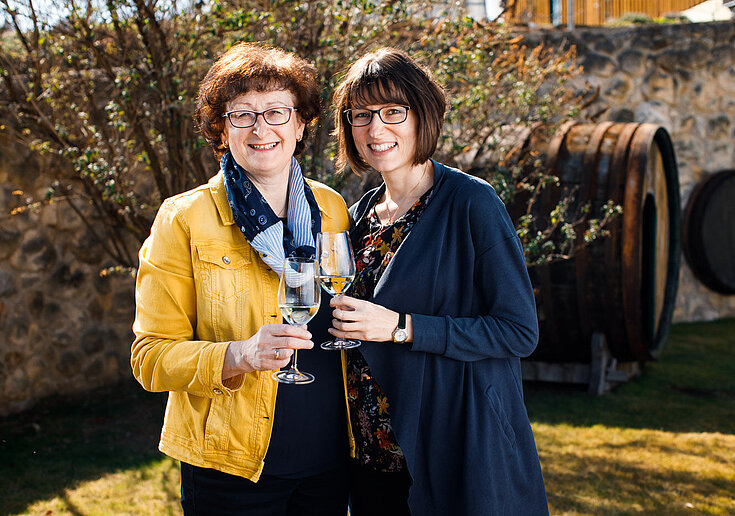Brigitte und Monika Neustifter mit einem Glas Wein in der Hand.