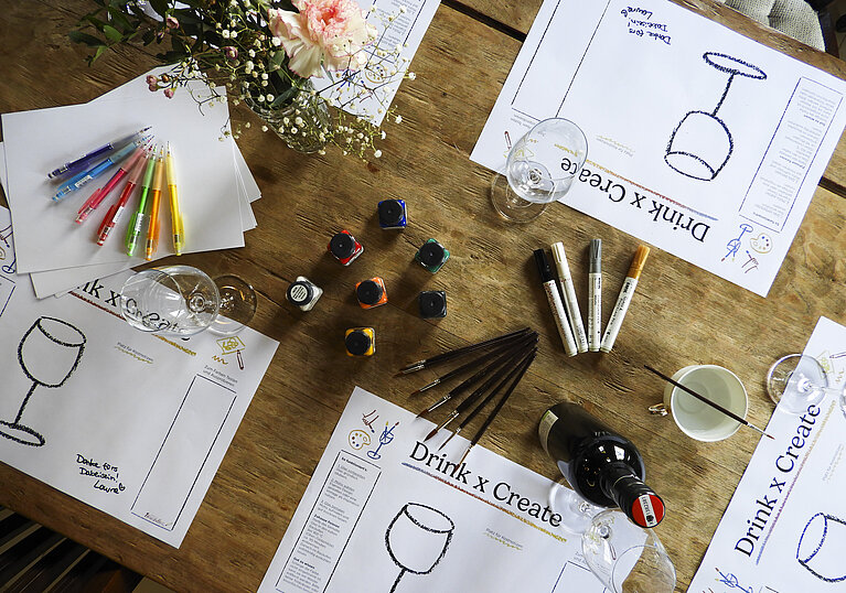 Table with painting supplies for decorating wine glasses